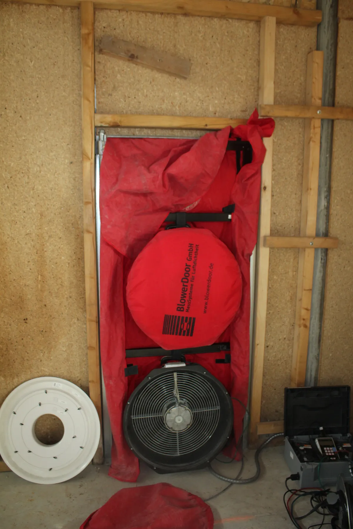 Porte soufflante installée pour le test d’étanchéité à l’air final, première étape avant l’attestation RE2020.